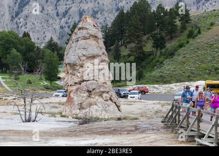 YELLOWSTONE NATIONAL PARK, USA - 14 2014 luglio: Un gruppo di turisti che passano davanti al cono dormiente delle sorgenti termali di Liberty Cap nel Parco Nazionale di Yellowstone, Wyo Foto Stock