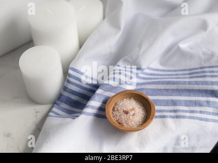 vasca da bagno con sale su lino su marmo con candele bianche Foto Stock