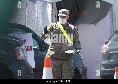 New York, New York, Stati Uniti. 11 Aprile 2020. I soldati della Guardia Nazionale di New York schermano il traffico in un centro di test drive-through COVID-19 nella sezione Flatbush del Borough di Brooklyn. Credit: Bryan Smith/ZUMA Wire/Alamy Live News Foto Stock