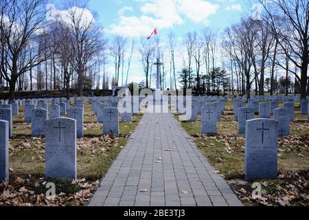 Percorso lastricato che conduce alla Croce del sacrificio nella sezione delle tombe di guerra del Commonwealth (CWGC) del cimitero di Beechwood a Ottawa, Ontario, Canada. Foto Stock