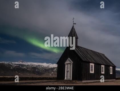 Aurora boreale sulla chiesa nera in Islanda Foto Stock