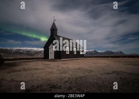 Aurora boreale sulla chiesa nera in Islanda Foto Stock