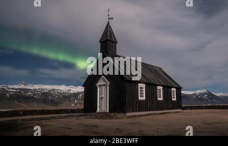 Aurora boreale sulla chiesa nera in Islanda Foto Stock