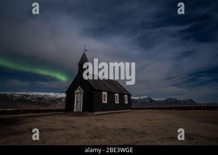Aurora boreale sulla chiesa nera in Islanda Foto Stock