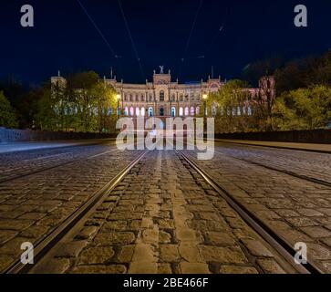 Simmetria dei tram di fronte al Bayrischer Landtag nella città di Monaco di notte. Foto Stock