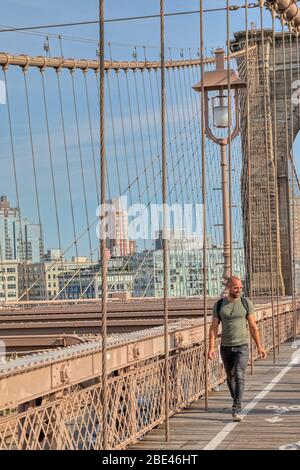 Il New Yorker attraversa il ponte di Brooklyn Foto Stock