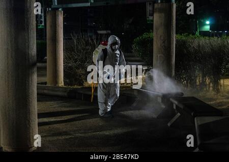 Il personale addetto alla pulizia a piedi disinfetta una piazza e strade. Giorno della notte pulizia e disinfezione nelle strade di Caracas, Venezuela, per prevenire il spr Foto Stock