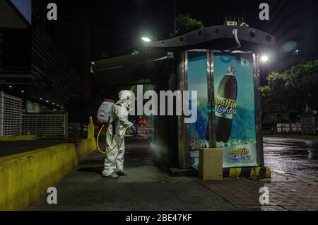 Il personale addetto alla pulizia a piedi disinfetta una piazza e strade. Giorno della notte pulizia e disinfezione nelle strade di Caracas, Venezuela, per prevenire il spr Foto Stock