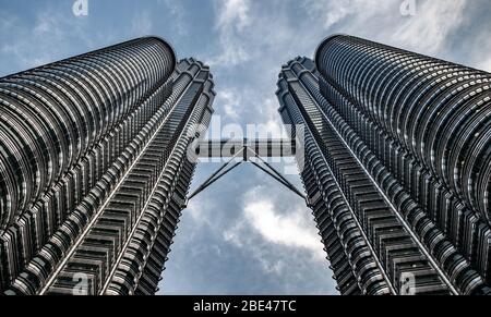 Vista simmetrica dal basso delle Torri Petronas a Kuala Lumpur - Vista simétrica desde abajo de las torres Petronas Foto Stock