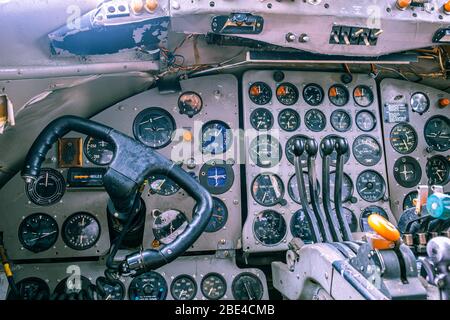 Vista in primo piano di un giogo in vecchio velivolo circondato da molti indicatori, leve e interruttori Foto Stock