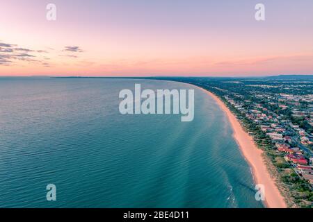 Panoramica costa di Port Phillip Bay con grattacieli del CBD di Melbourne all'orizzonte al tramonto - vista aerea Foto Stock