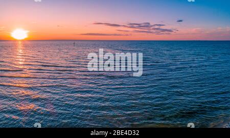 Panorama aereo del sole tramontare sul mare Foto Stock