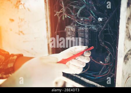 tecnico che indaga sulla causa dell'incendio, cortocircuito, scossa elettrica, armadio elettrico di controllo. Foto Stock