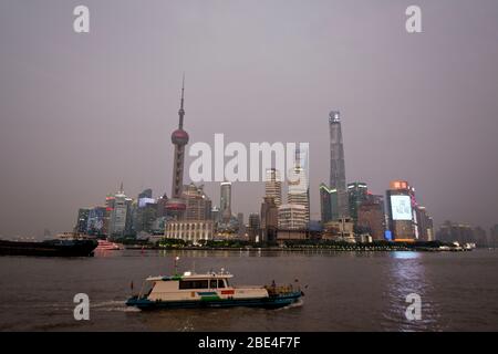 Lo skyline di Shanghai Pudong torreggia sul Fiume Huangpu, con vista dal Bund al crepuscolo. Cina Foto Stock