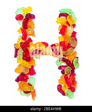 Lettera H dell'alfabeto inglese da marmellata multicolore su sfondo bianco isolato. Modello alimentare fatto da dolci per bambini orsi, dinosa Foto Stock
