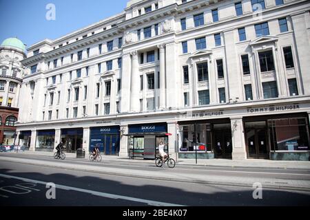 Londra, Regno Unito. 11 Aprile 2020. Giorno Nineteen di Lockdown a Londra. La gente pedala lungo Regent Street, poiché la maggior parte dei negozi sono chiusi durante la chiusura. E 'la prima festa pubblica dell'anno, e molte persone godono il lungo fine settimana di andare e circa o in vacanza, ma quest'anno il paese è in blocco a causa della pandemia Coronavirus COVID-19. La gente non è autorizzata lasciare la sede tranne per shopping di alimento minimo, trattamento medico, esercitazione - una volta al giorno e lavoro essenziale. COVID-19 Coronavirus lockdown, Londra, Regno Unito, il 11 aprile 2020 Credit: Paul Marriott/Alamy Live News Foto Stock