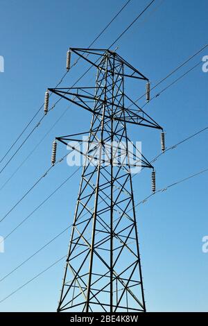 Elettricità Pylon in una giornata di sole con un cielo blu in Inghilterra, Regno Unito Foto Stock