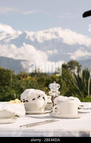 Tavolo colazione in una terrazza panoramica, con la catena montuosa Annapurna nell'Himalaya, in una località di lusso a Pokhara, Nepal Foto Stock