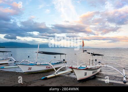 Vista orizzontale di Outrigger sulla spiaggia di Lovina a Bali all'alba, Indonesia. Foto Stock