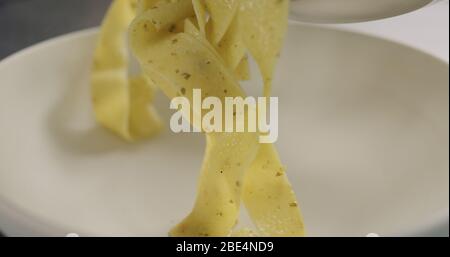 mettere le tagliatelle con il pollo e il pesto nel recipiente Foto Stock