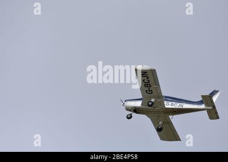 Un Piper PA28-140 Cherokee motore singolo, quattro posti, aereo leggero nel cielo sopra Bristol Airport, G BCJN Foto Stock