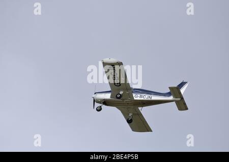 Un Piper PA28-140 Cherokee motore singolo, quattro posti, aereo leggero nel cielo sopra Bristol Airport, G BCJN Foto Stock