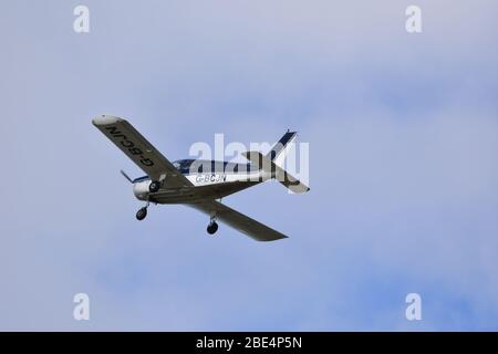 Un Piper PA28-140 Cherokee motore singolo, quattro posti, aereo leggero nel cielo sopra Bristol Airport, G BCJN Foto Stock