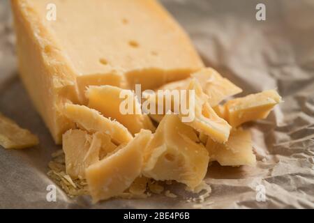 pezzi di formaggio stagionato su carta Foto Stock