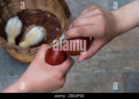 Due persone che schiantano le uova di pasqua rosse. Tradizione pasquale a Cipro Foto Stock