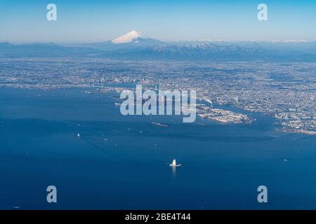 Monte Fuji sopra Yokohama e Kawasaki City, Prefettura di Kanagawa, Giappone. Vista dall'aereo alla baia di Tokyo. Foto Stock