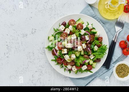 Insalata greca con feta e pomodori, cibo su sfondo bianco spazio copia vista dall'alto Foto Stock