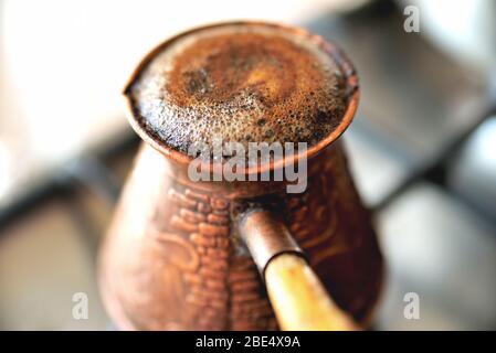 la vecchia macchina per il caffè si trasforma in una stufe, caffè bollente in schiuma, primo piano della mattina Foto Stock