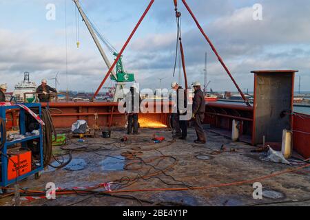 Saldatori del cantiere navale Orskov in Danimarca che lavorano sul lato di una nave sismica in fase di riadattamento in Dry Dock. Foto Stock