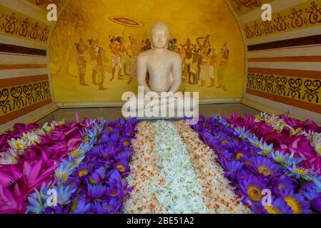 Antica scultura di un Buddha seduto nel disegno del tempio buddista Thuparamaya Dagoba. Anuradhapura. Sri Lanka Foto Stock