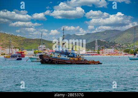 Un vecchio rimorchiatore di ruggine che naviga al largo della costa di Phillipsburg a St Martin Foto Stock