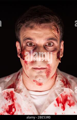 Primo piano di zombie sanguinoso su sfondo nero per Halloween. Trucco creativo. Foto Stock