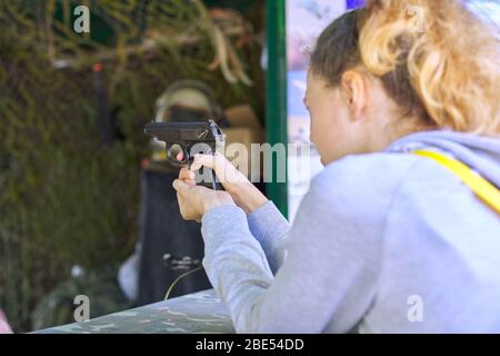 Primo piano della pistola di addestramento di tiro della ragazza teenage al campo di tiro. Foto Stock