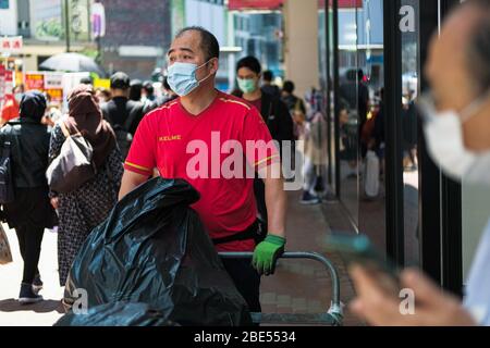 Hong Kong, Cina. 12 aprile 2020. La gente indossa una maschera chirurgica per il viso sulla strada. Corona Virus (Covid19) casi a Hong Kong hanno raggiunto oltre 1,000 il sabato, come le autorità hanno esortato il pubblico a rimanere a casa durante il lungo weekend di Pasqua. Credit: Keith Tsuji/ZUMA Wire/Alamy Live News Foto Stock