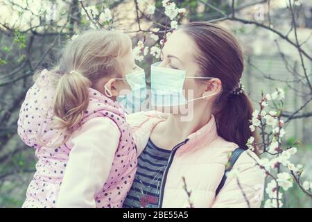 Figlia e madre indossano maschere per strada. Virus pandemico. Foto Stock