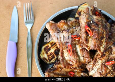 Costine di maiale grigliate in un piatto di acciaio inossidabile. Appetitoso carne pronta, picnic. Foto Stock