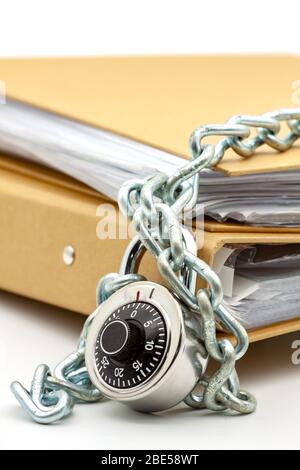 Cartelle di documenti di cartone bloccate con catena e lucchetto. Messa a fuoco selettiva con profondità di campo bassa. Foto Stock