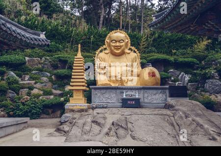 Busan, Corea del Sud, 12 settembre 2019: Buddha d'oro sorridente del Tempio di Haedong Yonggung Foto Stock