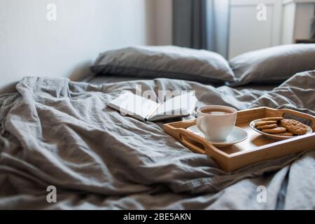 La prima colazione di tè e biscotti con un magazzino in un letto di grigio al mattino Foto Stock