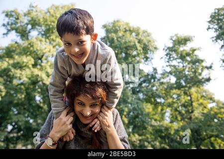 Madre che gioca con suo figlio fuori nel parco. Foto Stock