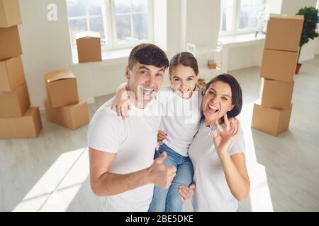 Chiavi con portachiavi in forma di casa di metallo da una nuova casa o  appartamento nelle mani di una giovane famiglia. La felicità di comprare  una casa Foto stock - Alamy