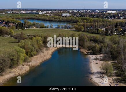 Berlino, Germania. 12 aprile 2020. Solo poche persone godono del bel tempo sulle rive dei laghi di Kaulsdorf. (Vista aerea con drone) Credit: Paul Zinken/dpa/Alamy Live News Foto Stock