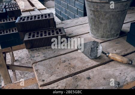 Un attrezzo di muratore da un piano di poppa nel posto di lavoro. Cazzuola  per muratura. Muratore di costruzione attrezzi di Malta di cemento Foto  stock - Alamy