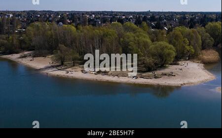 Berlino, Germania. 12 aprile 2020. Solo poche persone godono del bel tempo sulle rive dei laghi di Kaulsdorf. (Vista aerea con drone) Credit: Paul Zinken/dpa/Alamy Live News Foto Stock