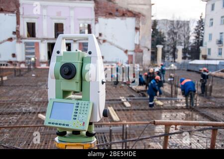 Costruzione teodolite sul sito durante la costruzione dell'edificio. Apparecchiature di misurazione nel cantiere. Foto Stock