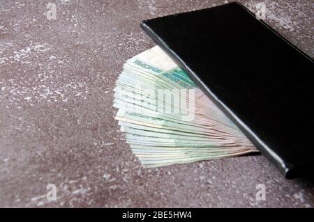 Denaro russo in un notebook nero. Pagamento per servizio. Ricompensa. Suggerimento Foto Stock